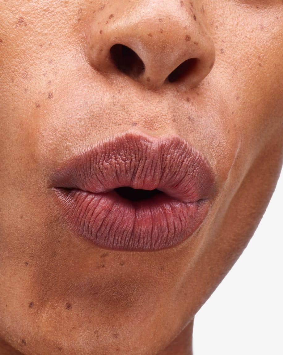 close up of model's mouth puckering lips wearing generation g in fuzz